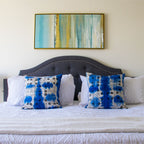 Bedroom with a bed featuring blue and white patterned mud cloth pillows