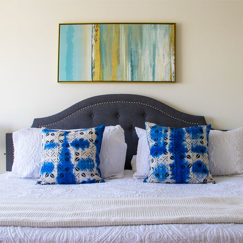 Bedroom with a bed featuring blue and white patterned mud cloth pillows