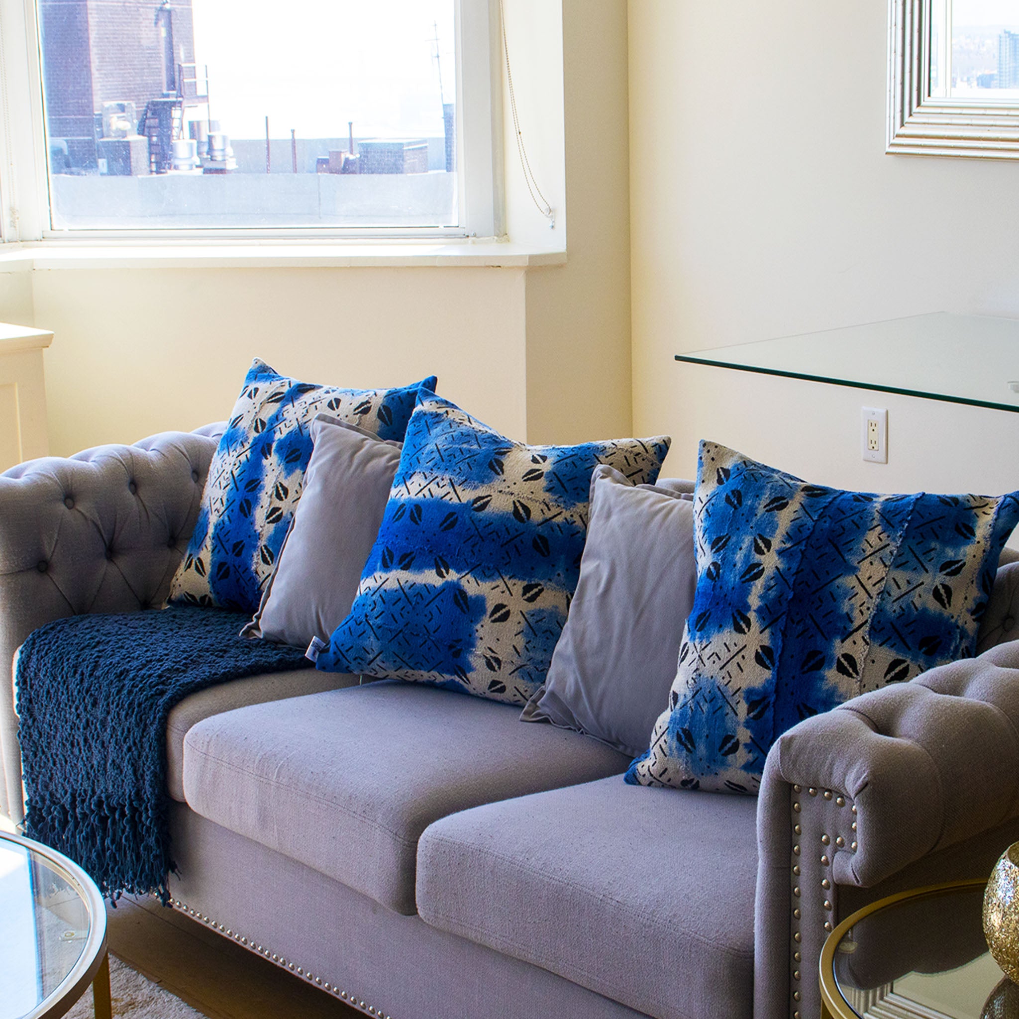  blue and white patterned mud cloth cushions in a living room setting.