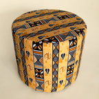 Top-angled view of the Drum Pouf showing full circular top and side panel in mustard, black, and brown African wax print